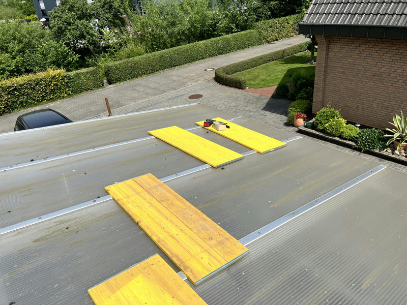 A car port roof from above, some planks and some tools