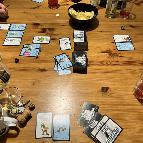 A table with Star Munchkin cards, beer and sparkling wine
